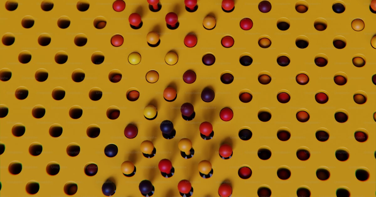 Une surface perforée jaune avec des boules rouges et bleues photo ...