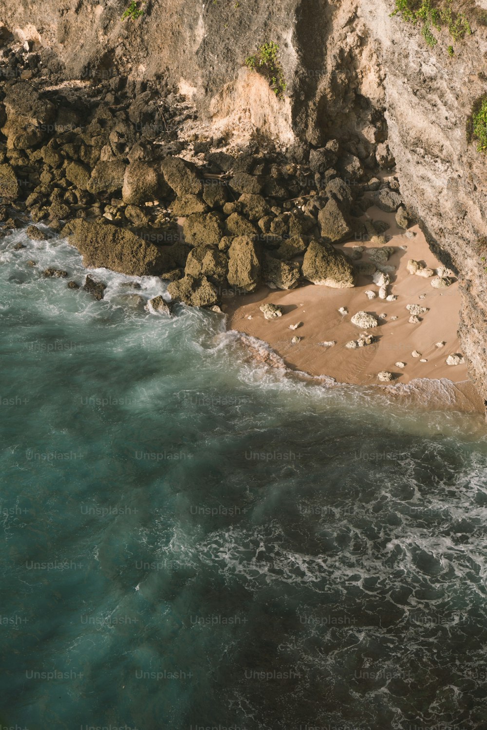 an aerial view of the ocean and a rocky cliff