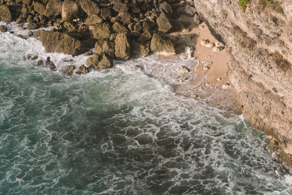 a bird's eye view of the ocean and a rocky cliff