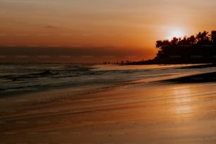 il sole sta tramontando sull'acqua in spiaggia