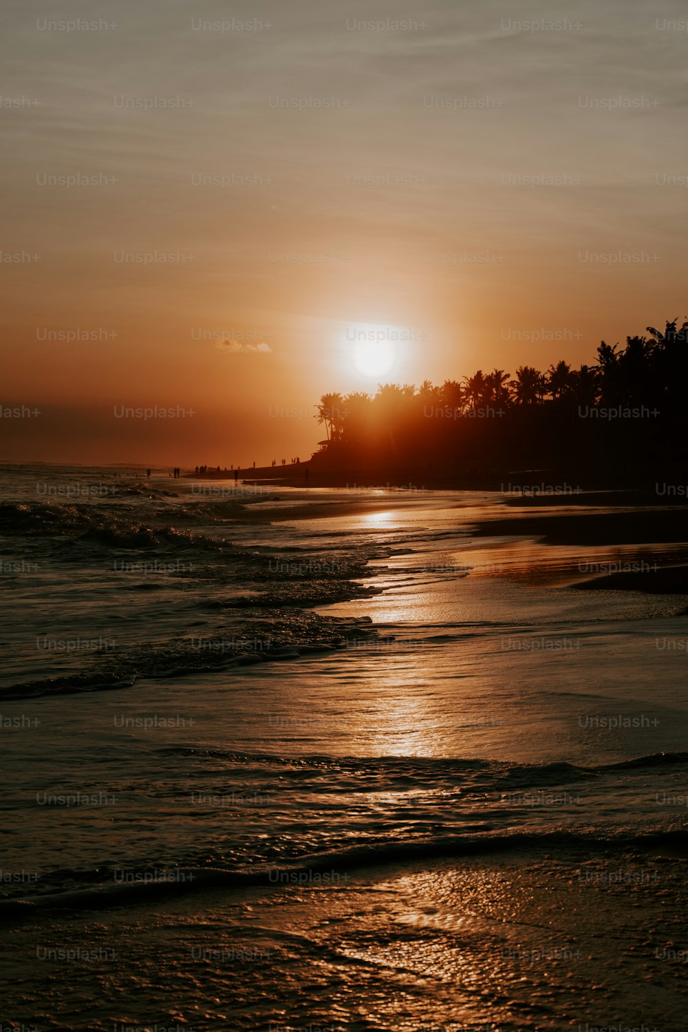 Die Sonne geht über dem Wasser am Strand unter