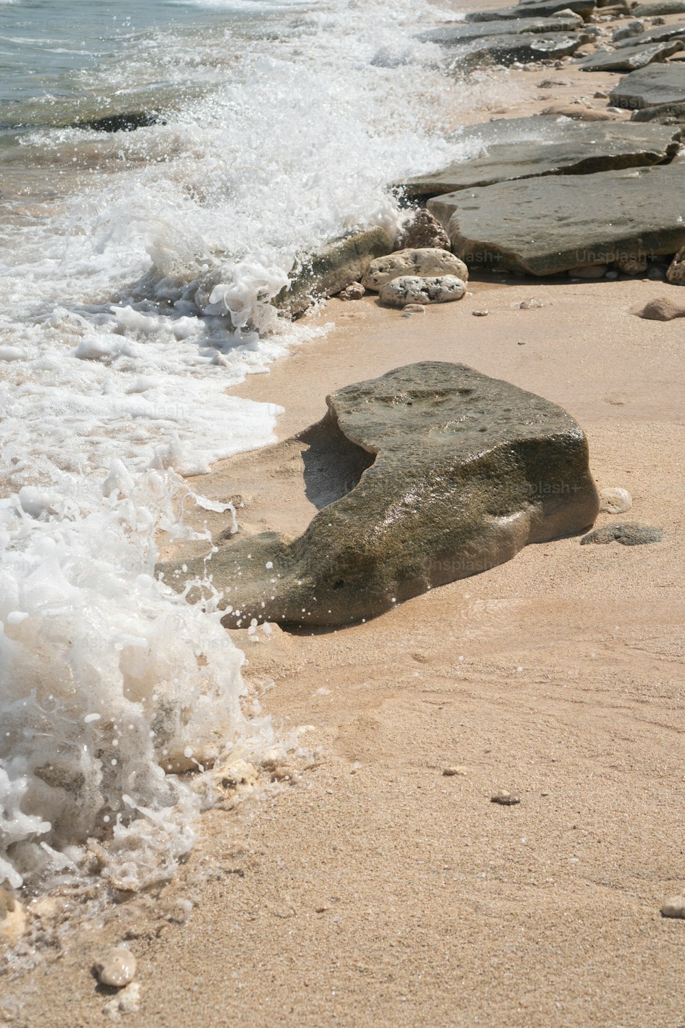 海の隣のビーチに横たわる岩