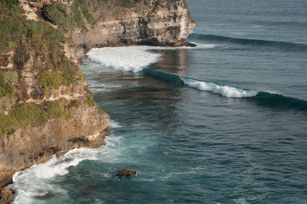 Un acantilado con una ola que viene del océano
