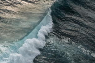 um grande corpo de água com uma onda vindo em direção à costa