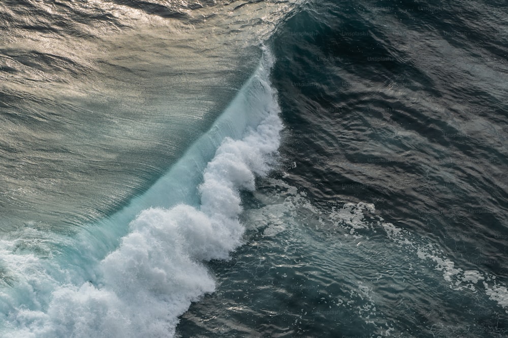 un grande specchio d'acqua con un'onda che arriva verso la riva