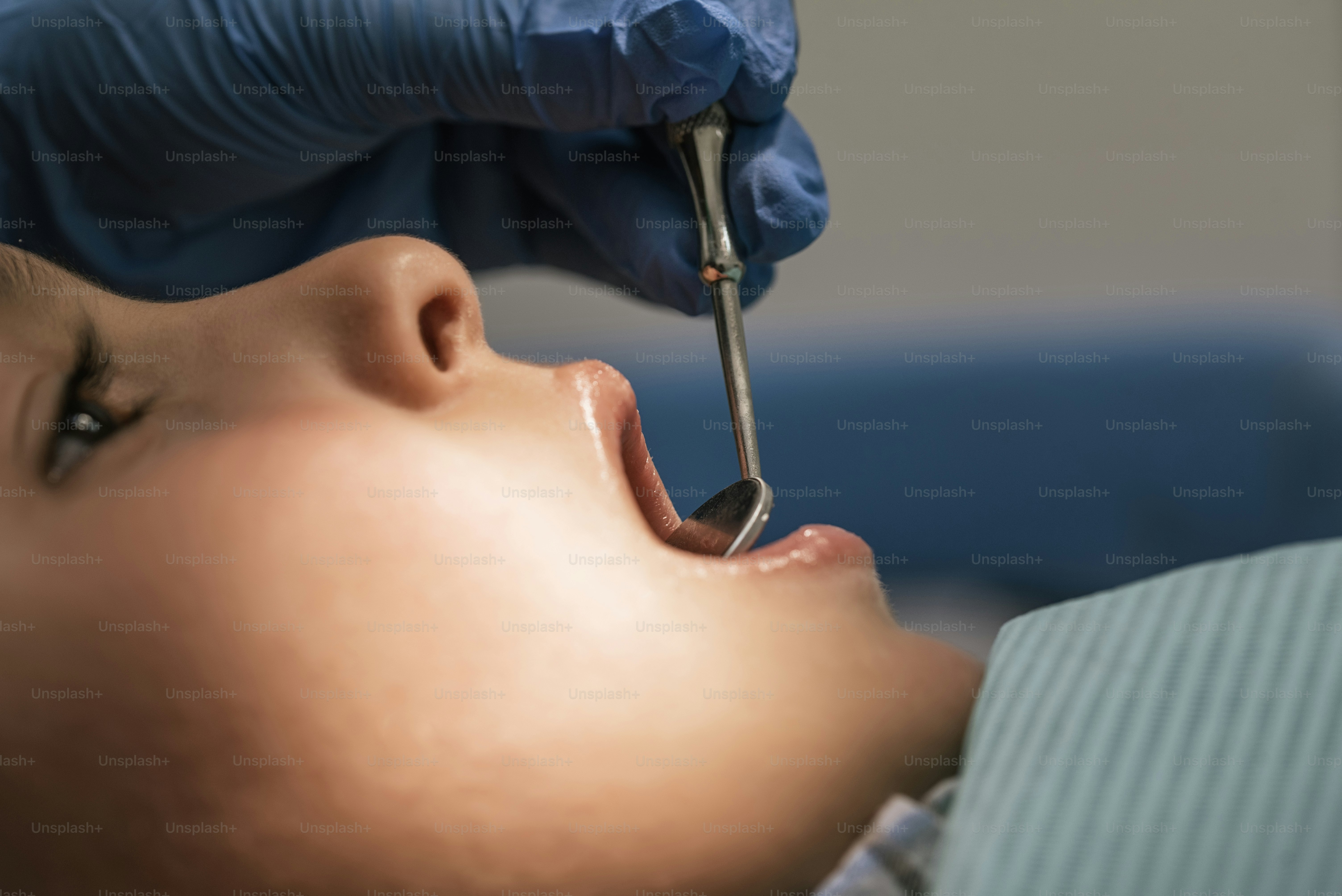Close up of dentist during a dental intervention with a patient. Dentist Concept