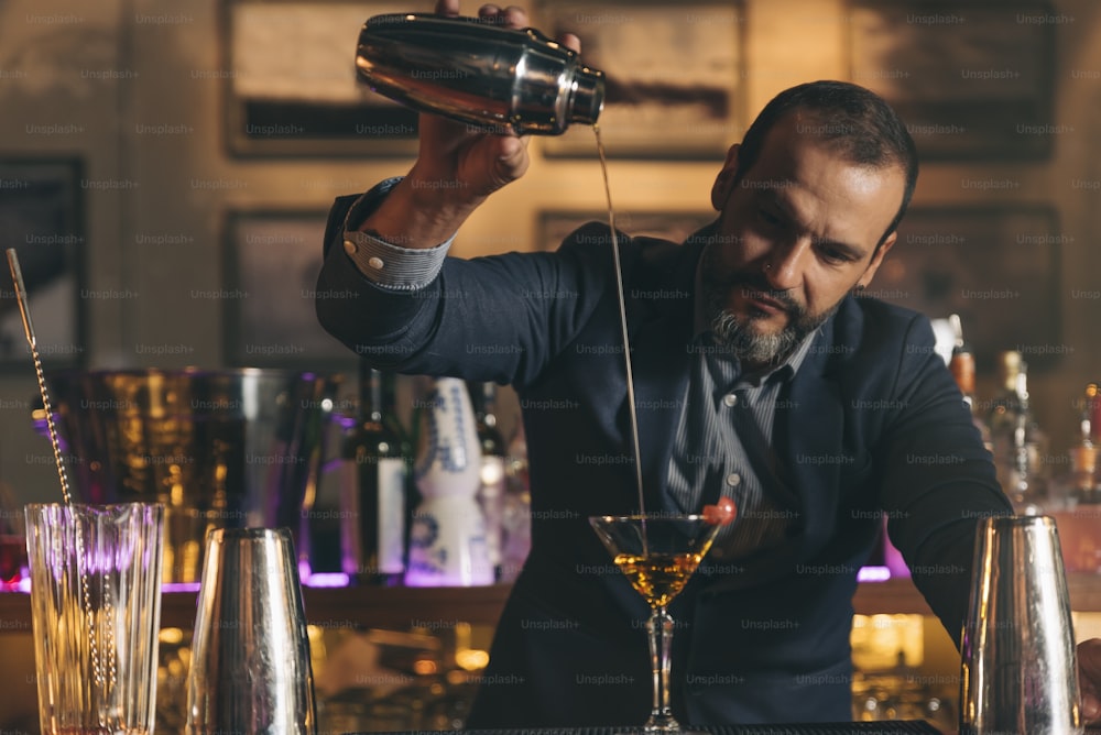 Un barman expert prépare un cocktail dans une boîte de nuit.