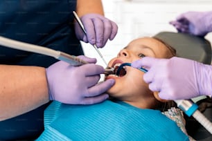 Banque d’images de mignonne petite fille pendant la révision chez le dentiste. Elle a la bouche ouverte.