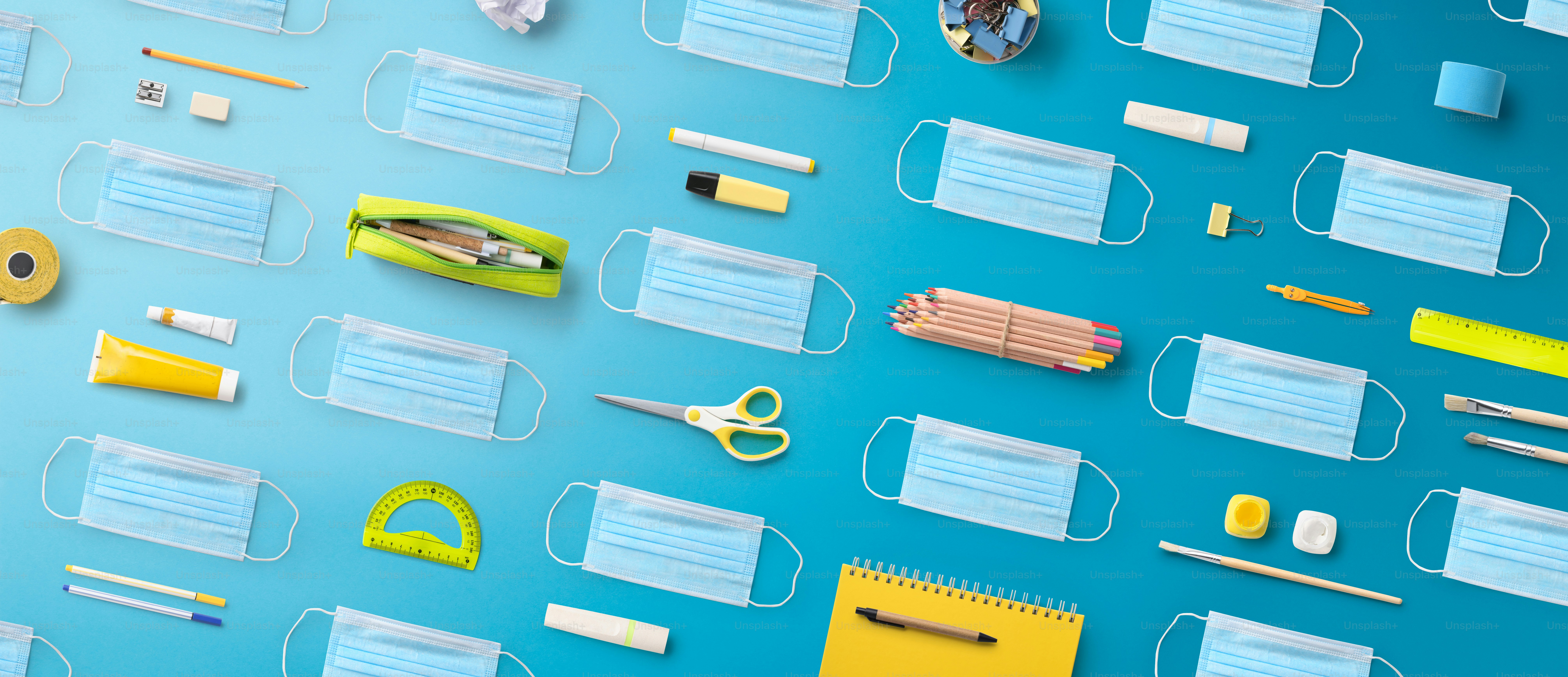 Flat lay top view of face mask, respirator and school supplies, back to school and coronavirus concept.