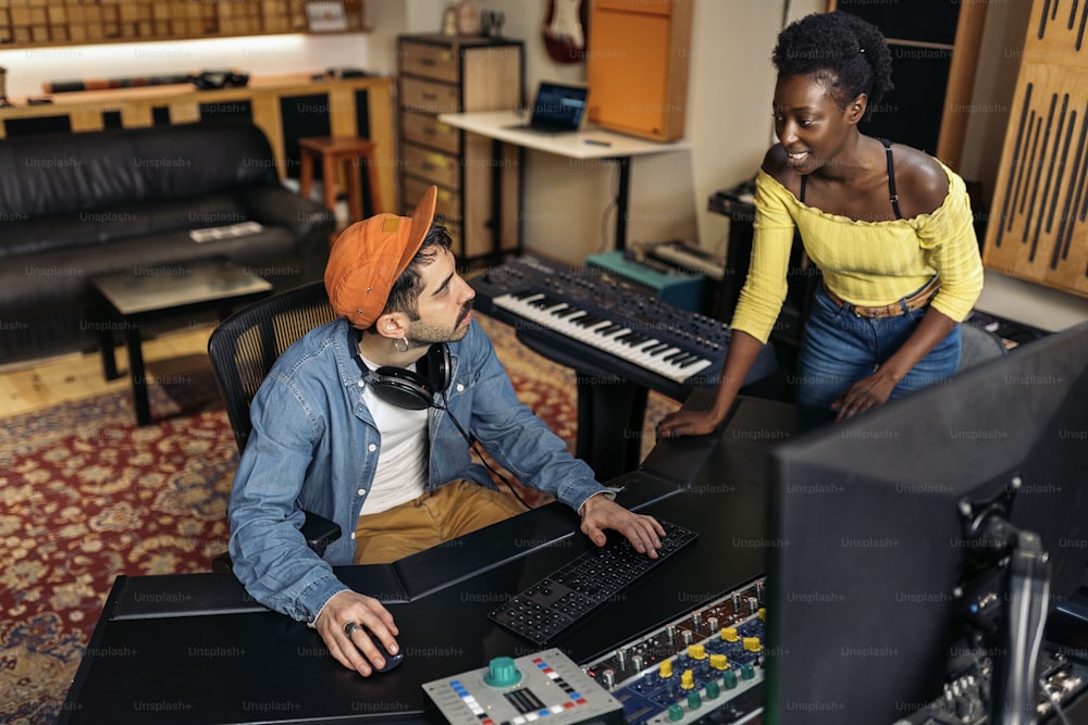 Stock photo of cool artists working in professional music studio.
