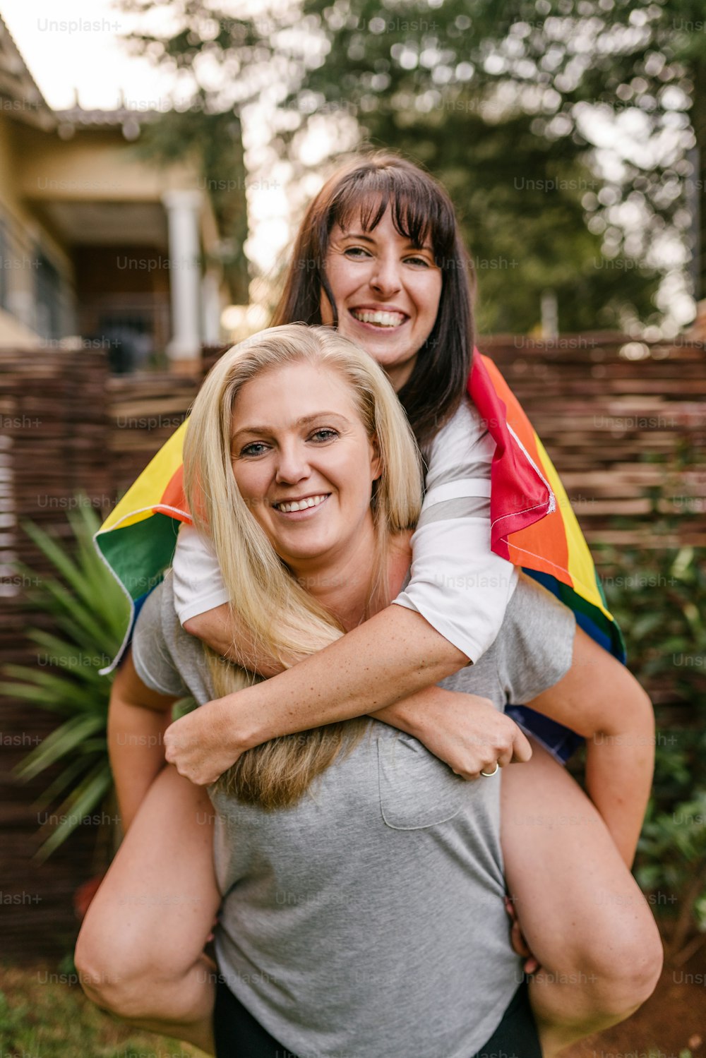 LGBT felice coppia lesbica orgogliosa che tiene la bandiera arcobaleno gay