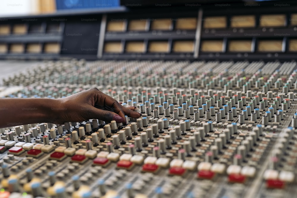 Stock photo of unrecognized person using panel control in professional music studio.
