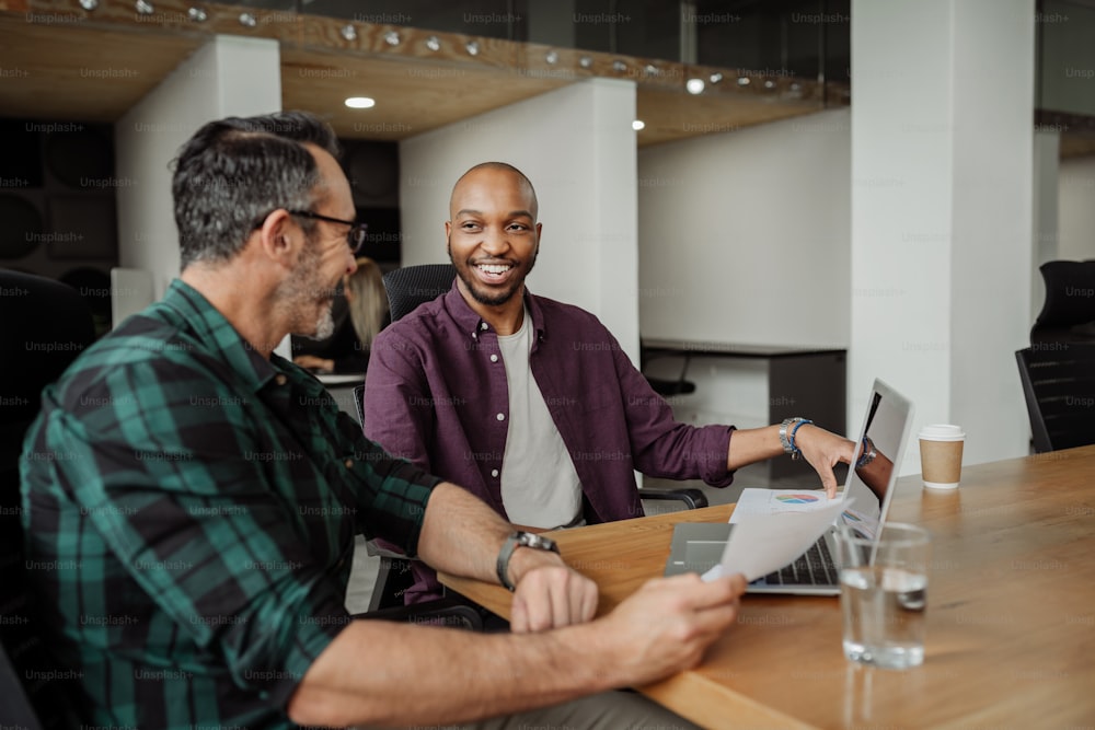 Deux hommes d’affaires différents travaillant dans un espace de coworking moderne. Rencontre franche