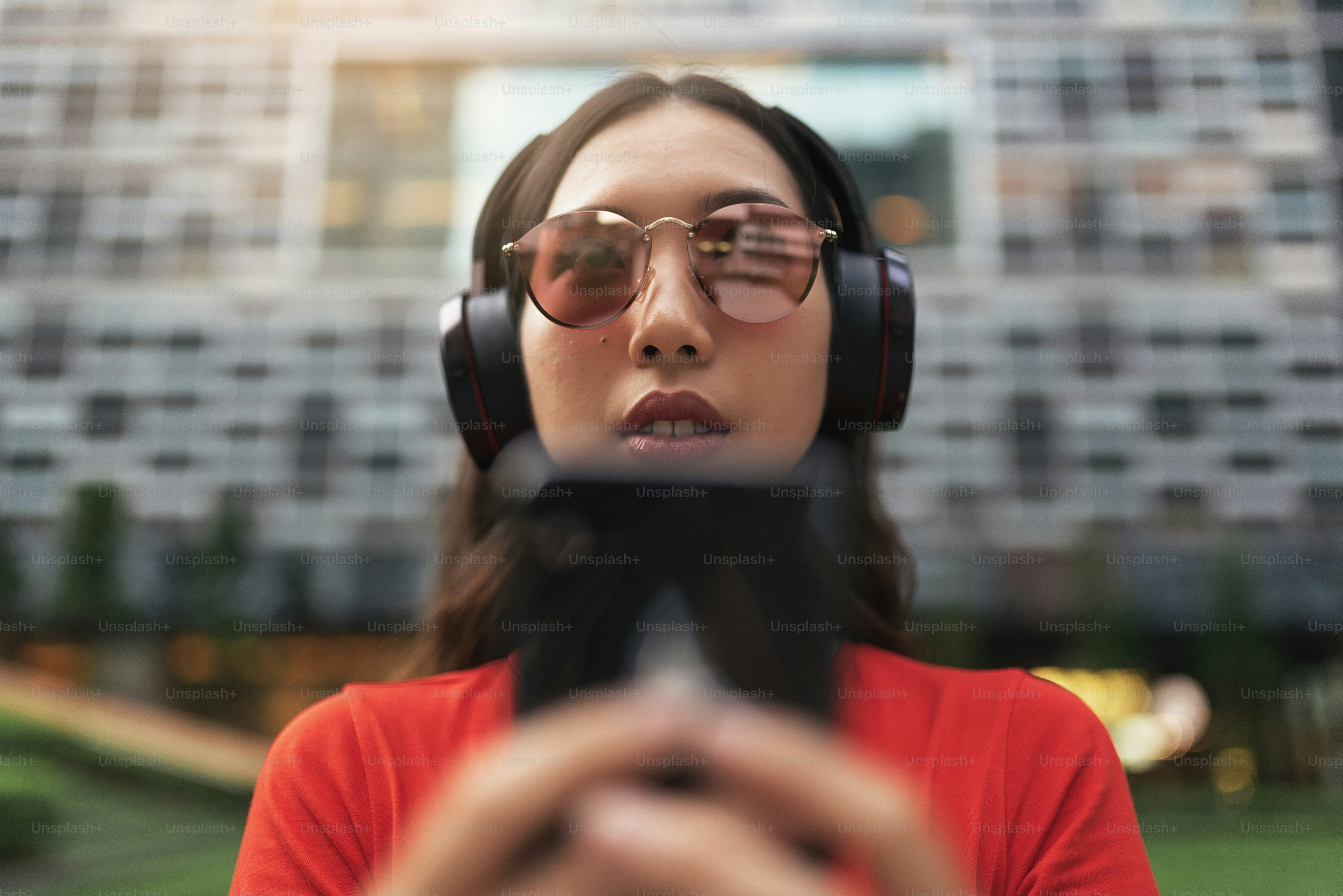 Foto zum Thema Schöne singapurische Frau, die Musik auf der Straße hört ...