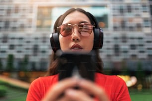 Beautiful singaporean woman listening music in the street.