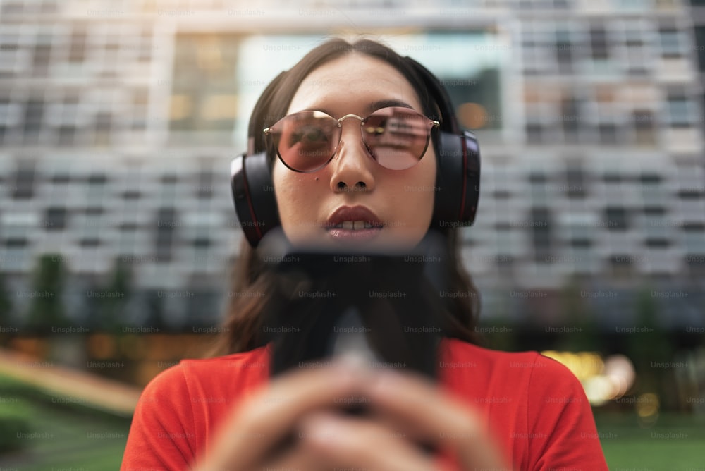 Beautiful singaporean woman listening music in the street.