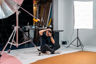 Stock photo of professional photographer during photo shoot in studio.