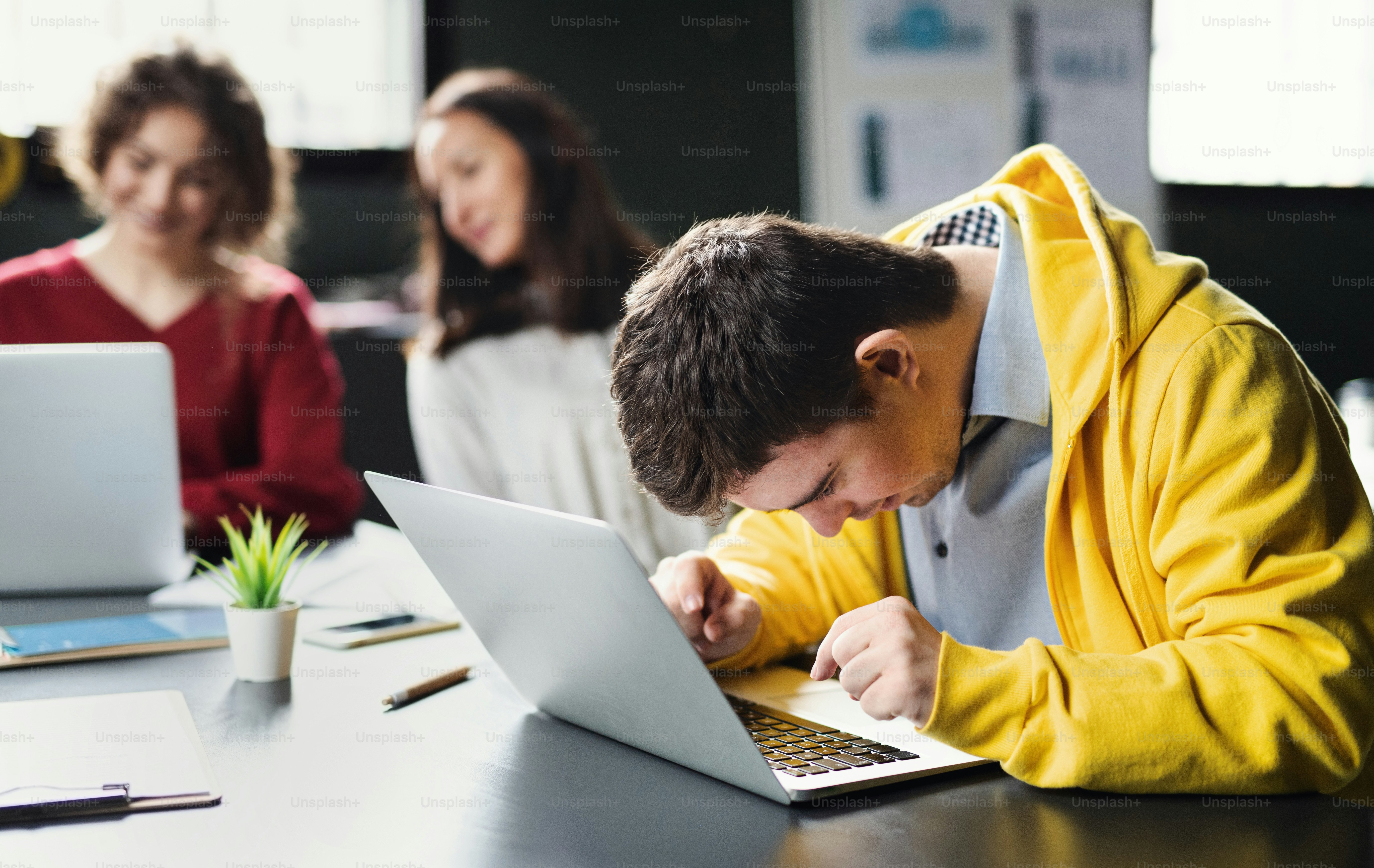 Seorang pria sindrom down dengan laptop menghadiri kelas pendidikan di pusat komunitas, inklusivitas penyandang disabilitas.
