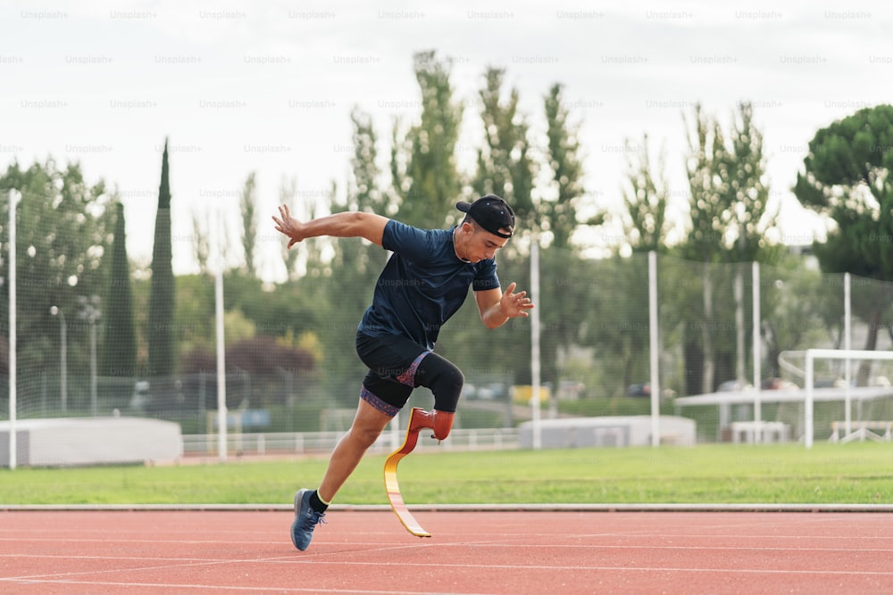 Stock photo of young athlete training with leg prosthesis in running track.