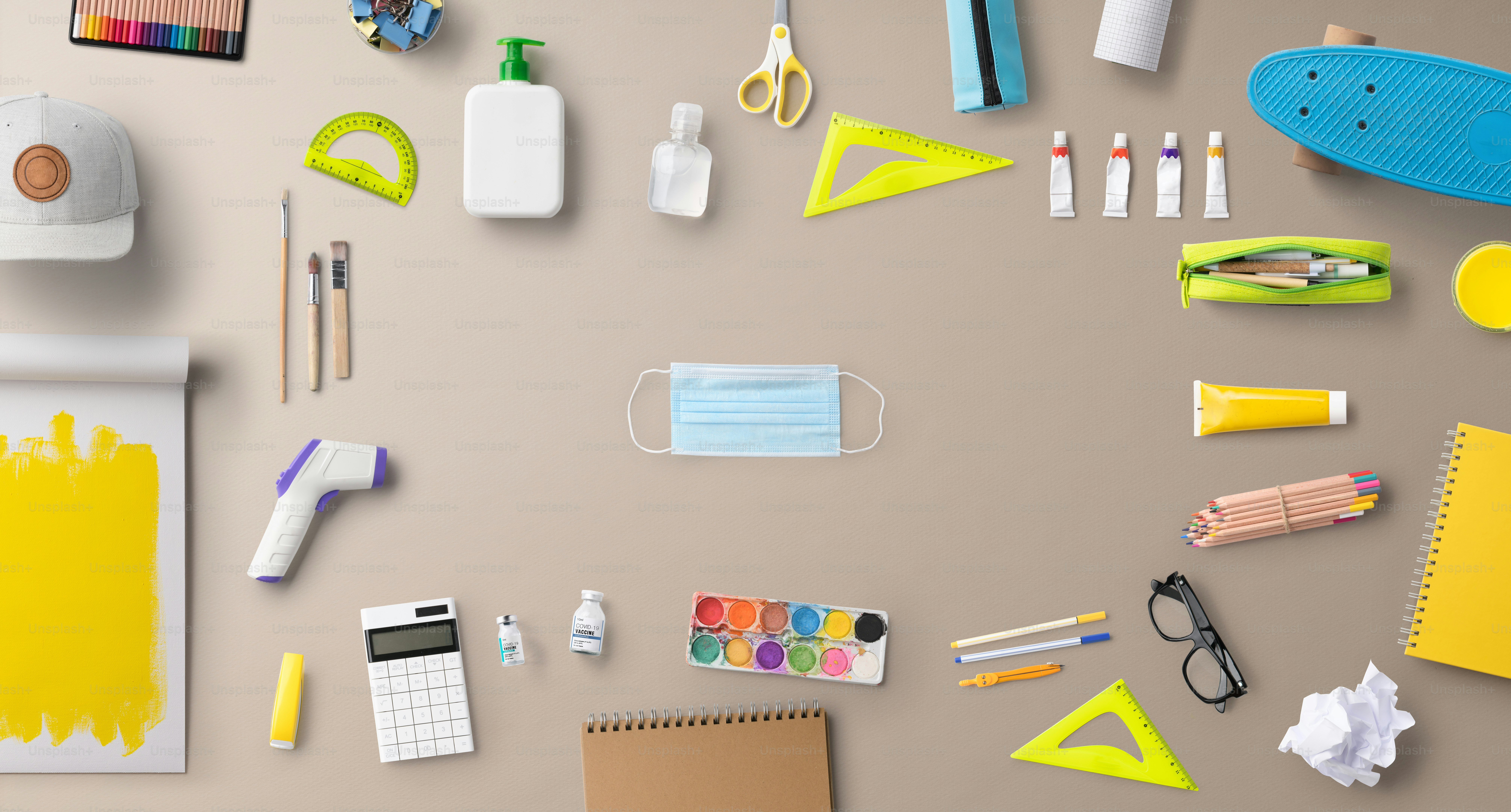 A flat lay top view of face mask and school supplies, back to school and coronavirus concept.