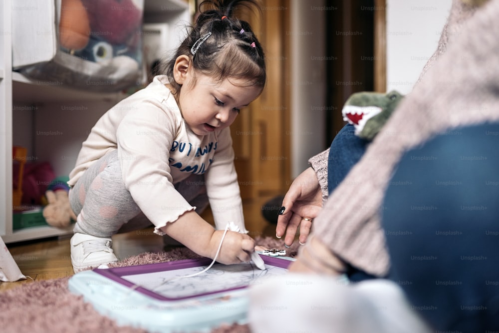 Stock photo of cute little girl having fun at home painting.
