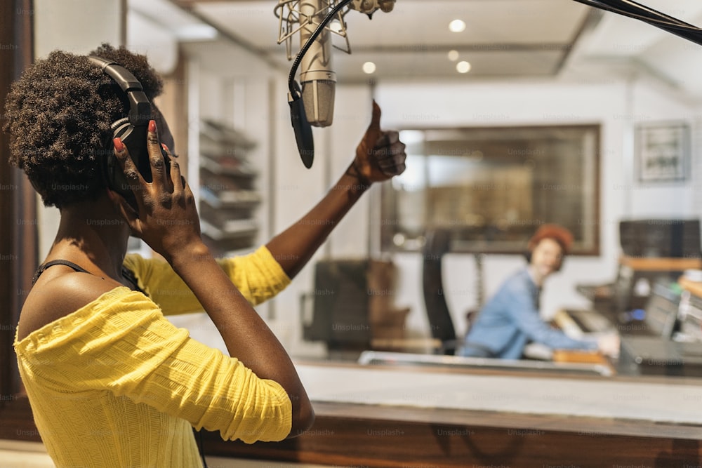 Banque d’images d’un producteur de musique travaillant avec un chanteur noir dans un studio de musique cool.