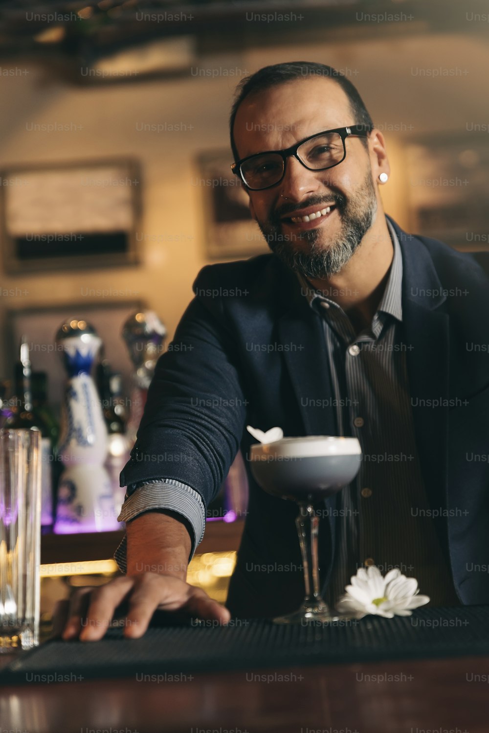 Expert barman is making cocktail at night club.