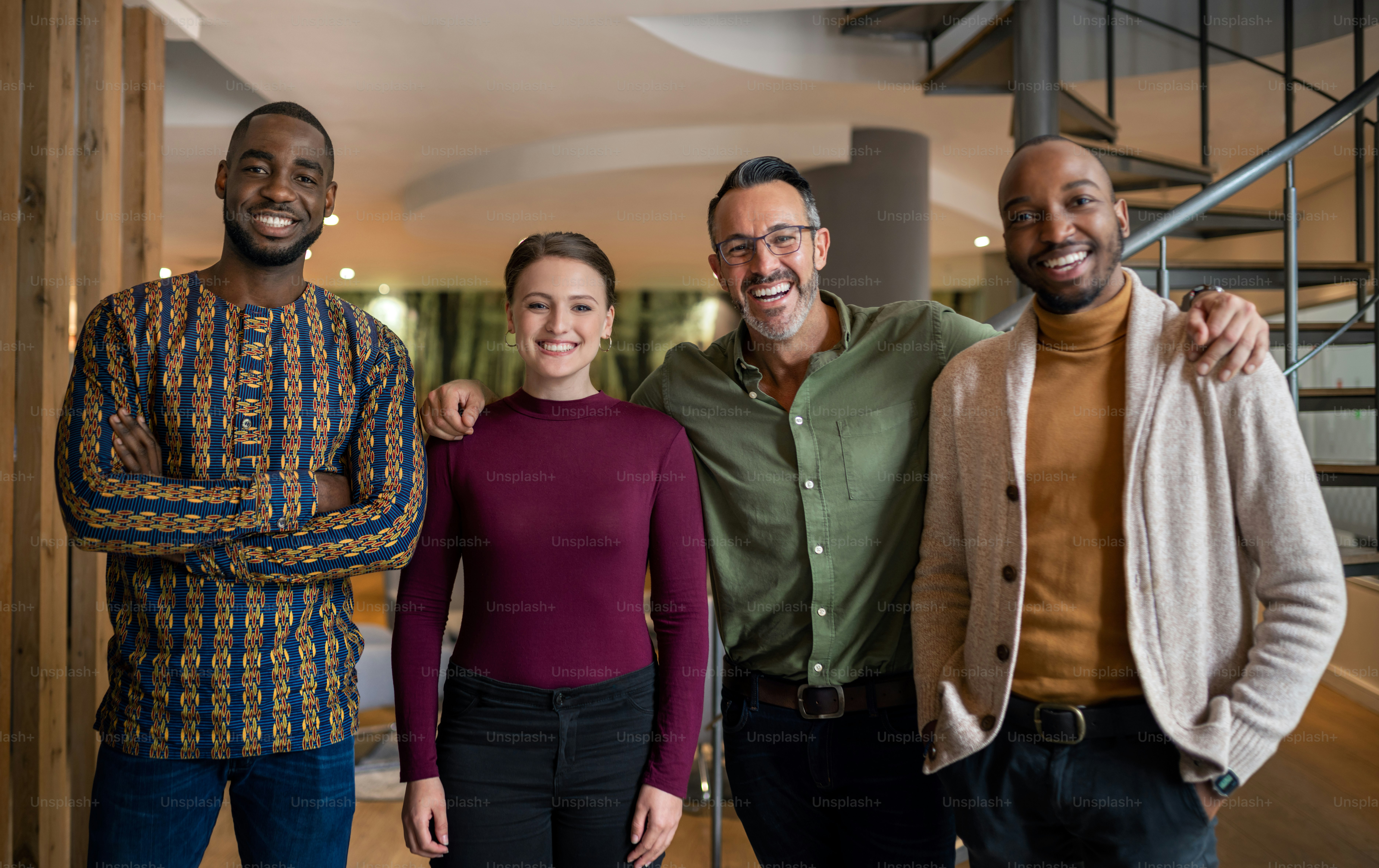 Portrait d’un groupe diversifié d’hommes d’affaires souriants tout en se tenant ensemble dans un bureau