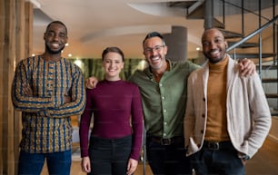 Retrato de un grupo diverso de empresarios sonriendo mientras están juntos en una oficina