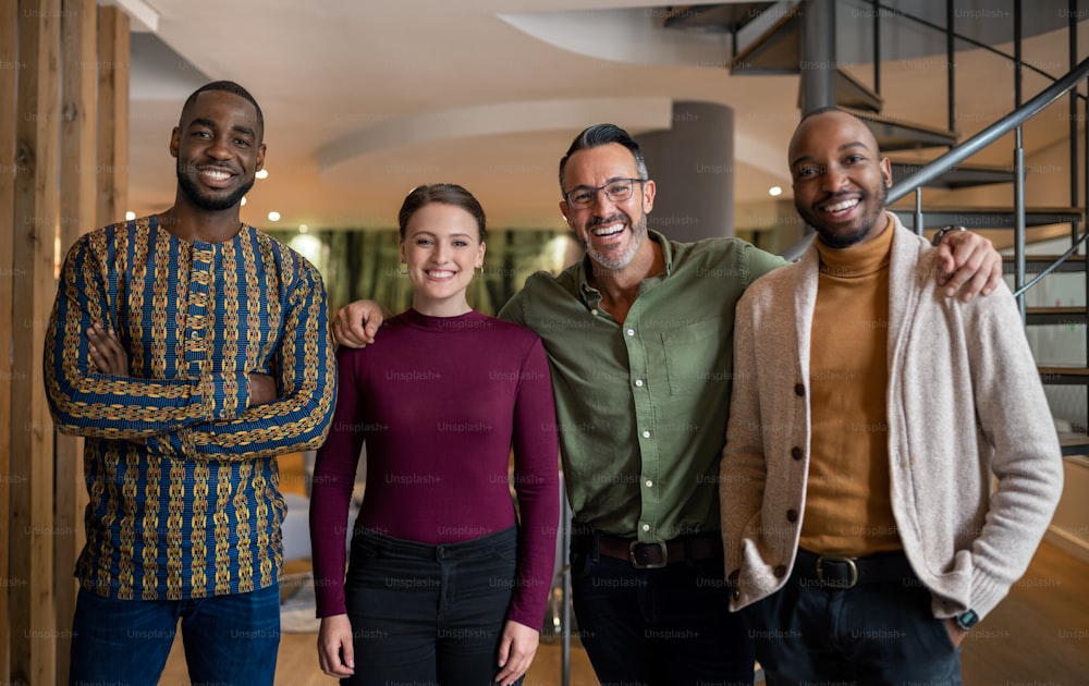 Portrait of a diverse group of businesspeople smiling while standing together in an office