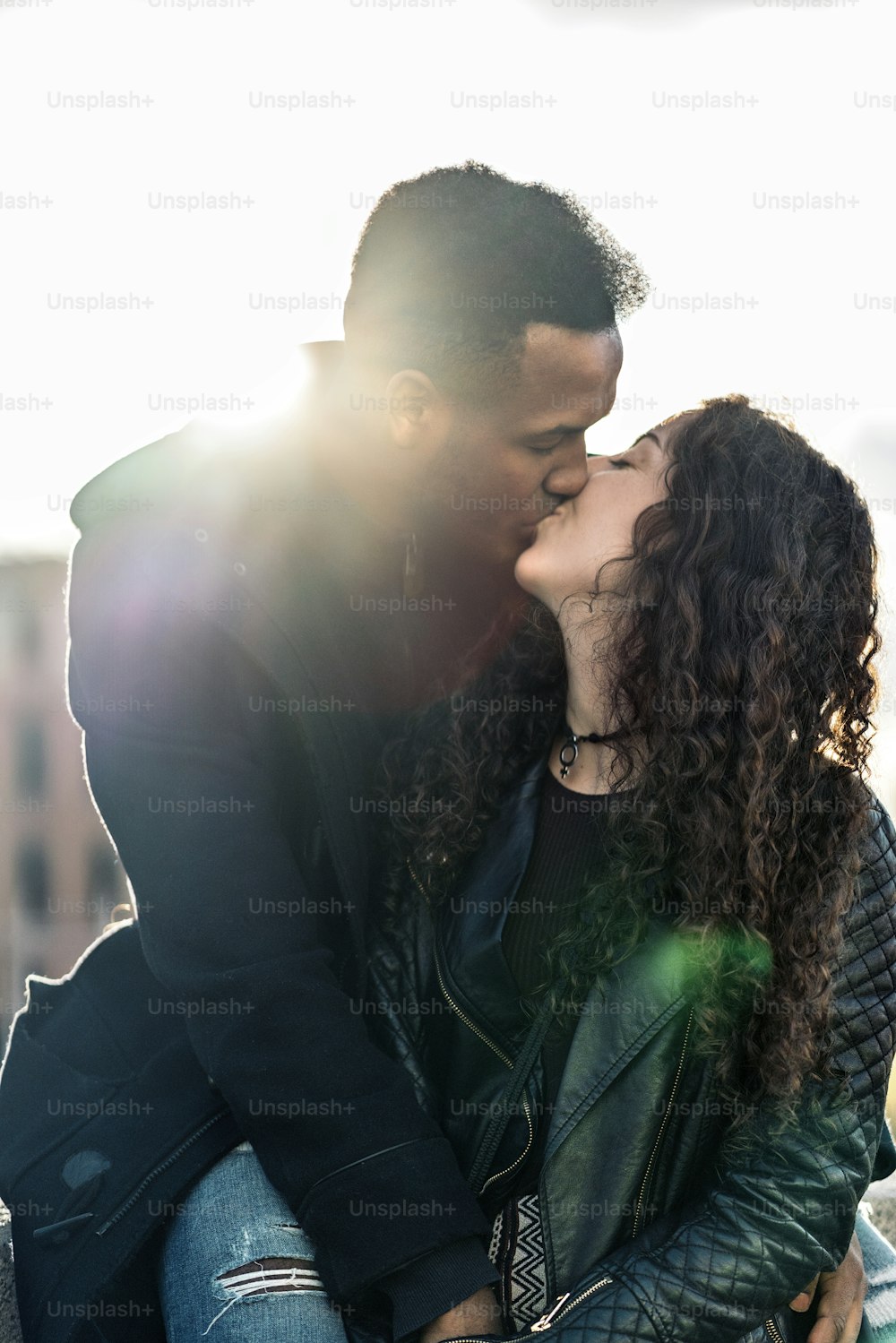 Stock photo of happy moment of interracial couple of lovers kissing.