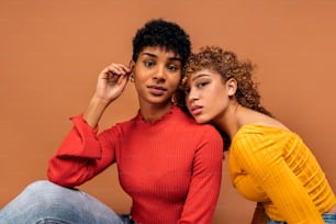 Stock photo of beautiful afro women posing in studio shot against brown background.