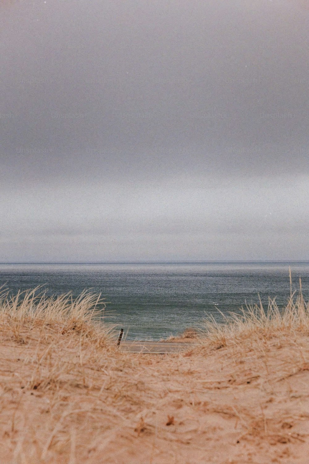 a lone surfboard sitting on top of a sandy beach