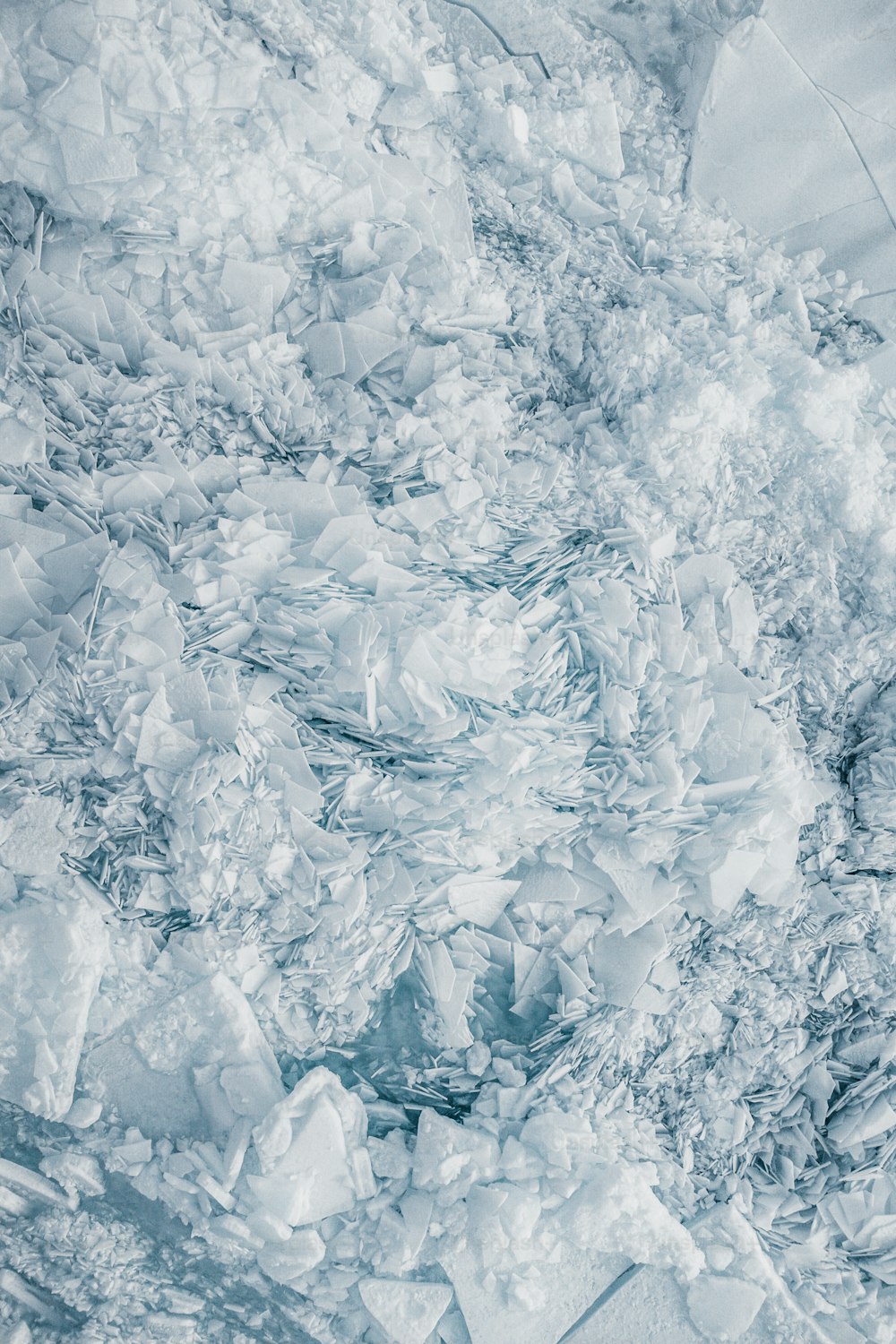uma grande quantidade de gelo flutuando em cima de um corpo de água