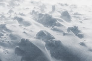 un sol enneigé avec des roches et de la neige