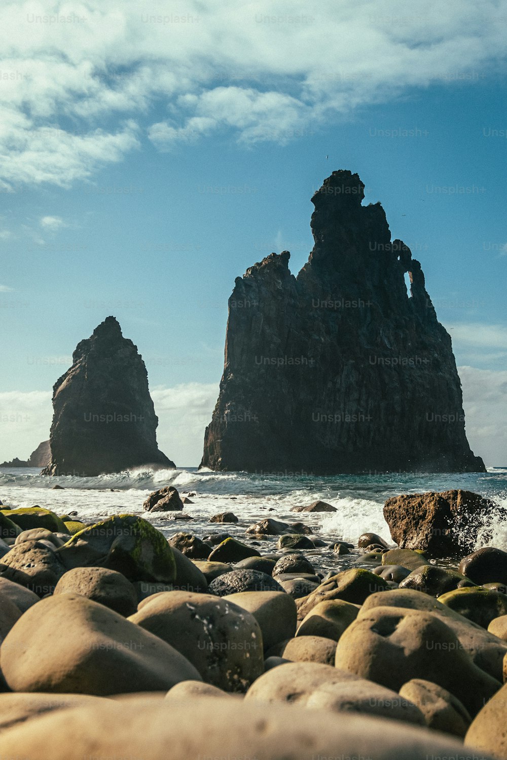 Una playa rocosa con grandes rocas en primer plano