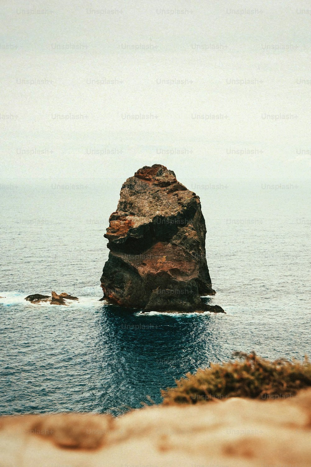 a large rock sticking out of the ocean