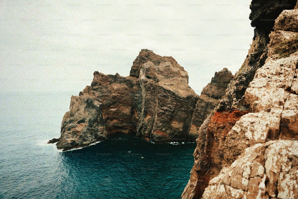 a large rock outcropping in the middle of a body of water