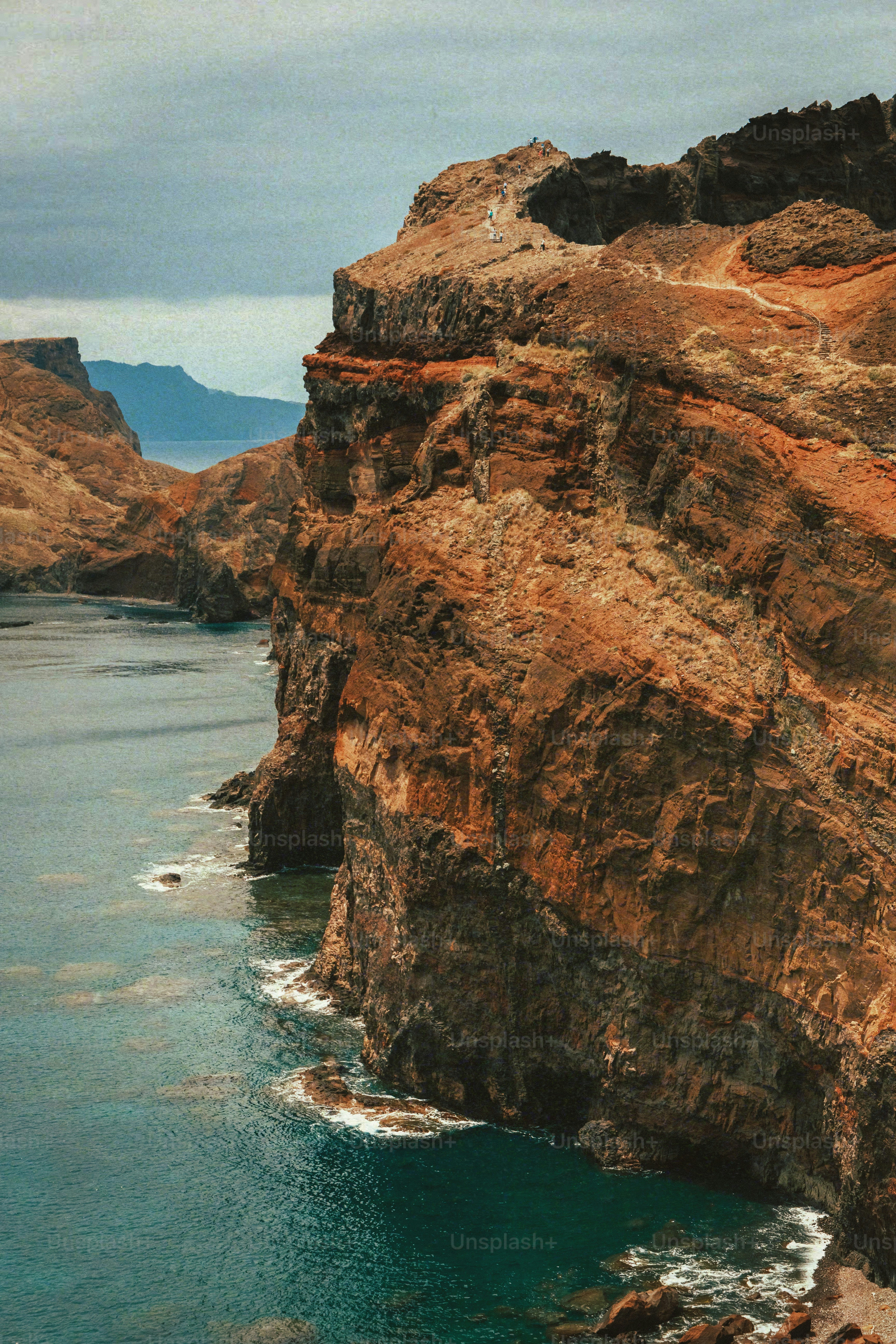 a couple of large rocks sitting next to a body of water