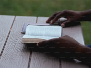 a person sitting at a table with a book and a mouse