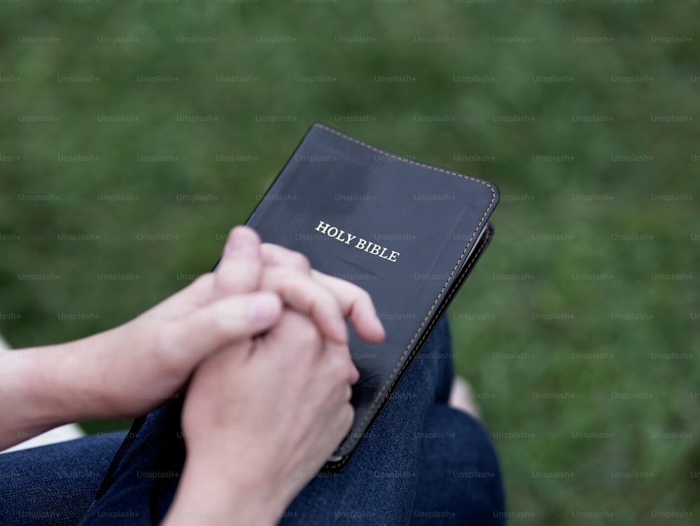 a person holding a bible in their hands