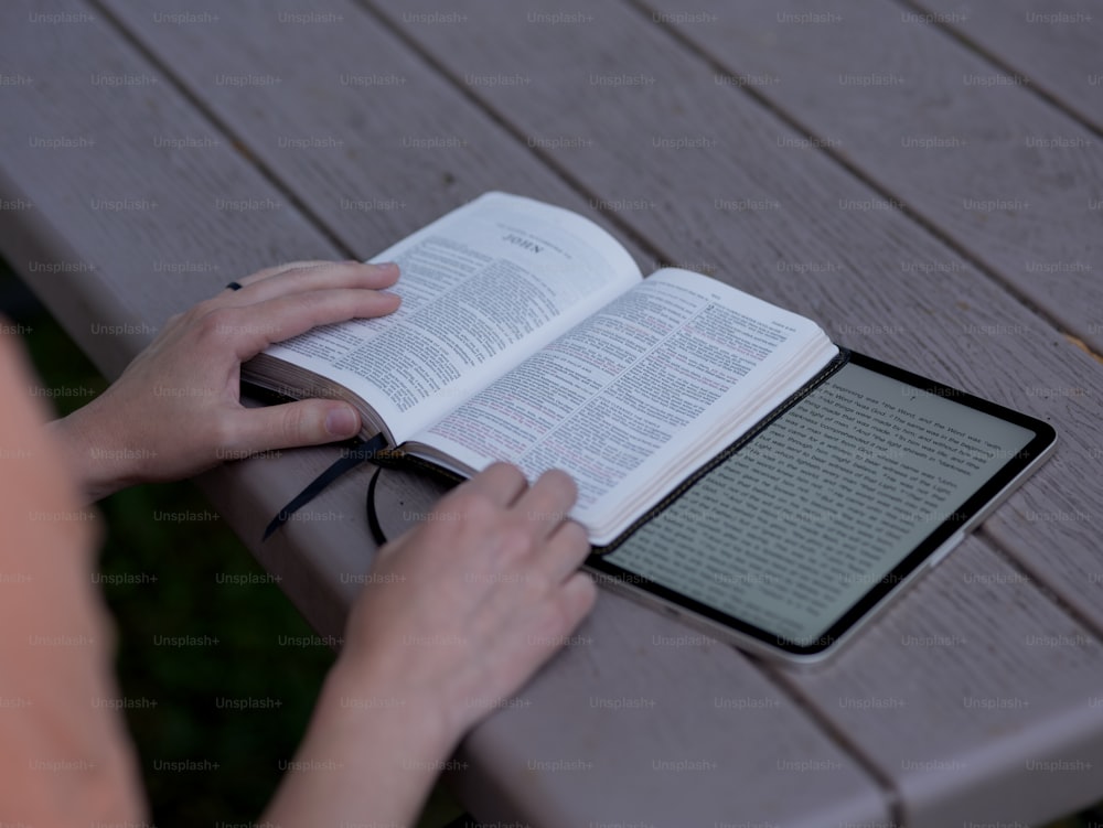 a person is reading a book on a bench