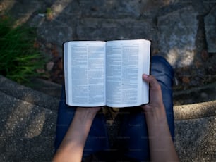 eine Person, die auf dem Boden sitzt und ein Buch liest