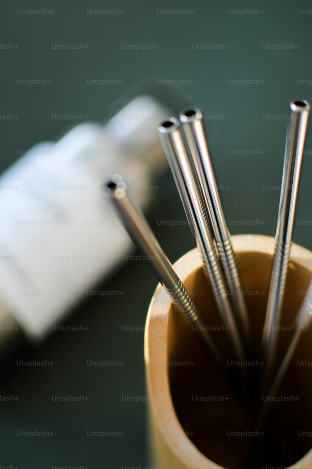 a close up of a cup filled with metal straws