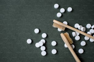 a couple of toothbrushes sitting next to a pile of pills