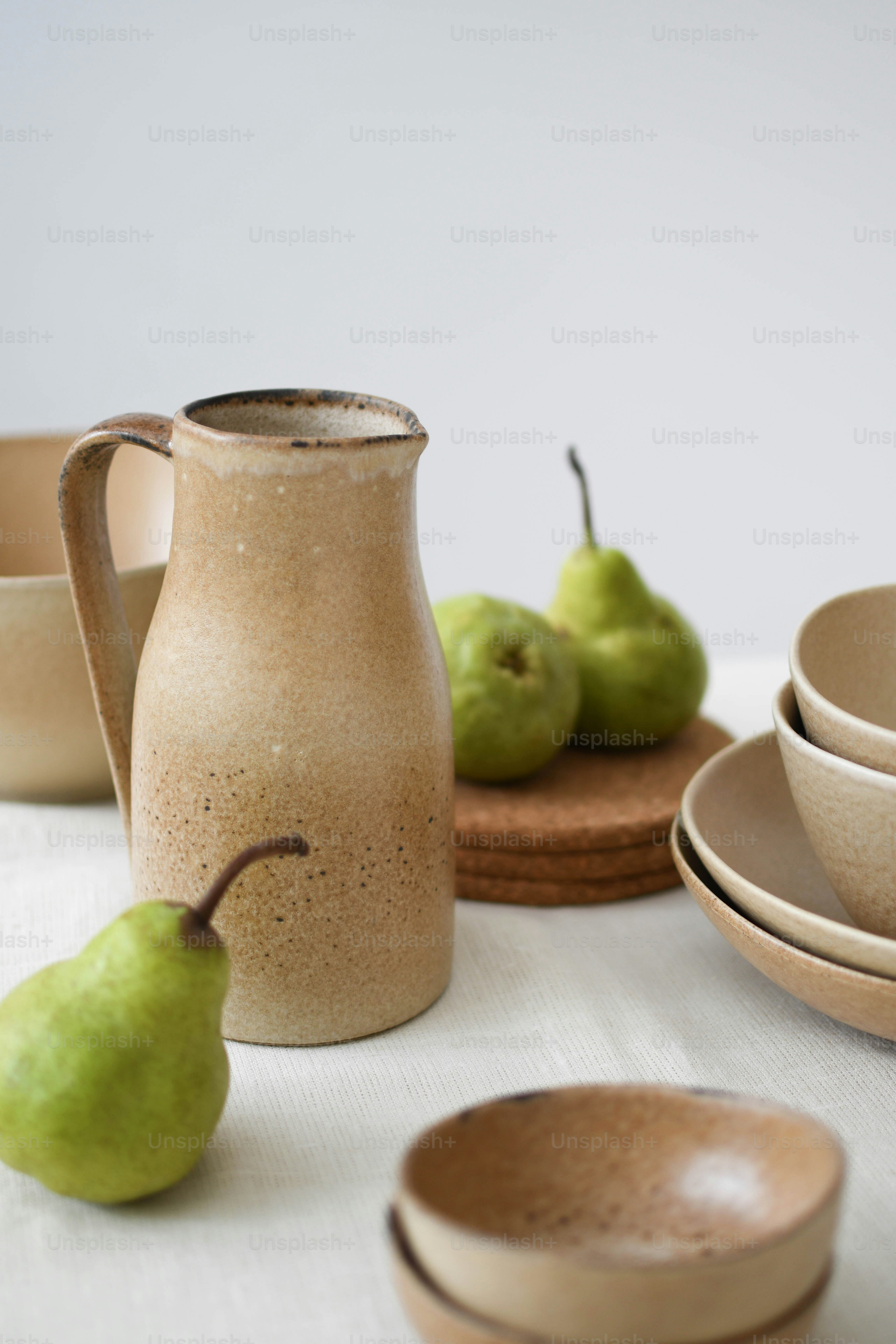 a table topped with plates and bowls filled with pears
