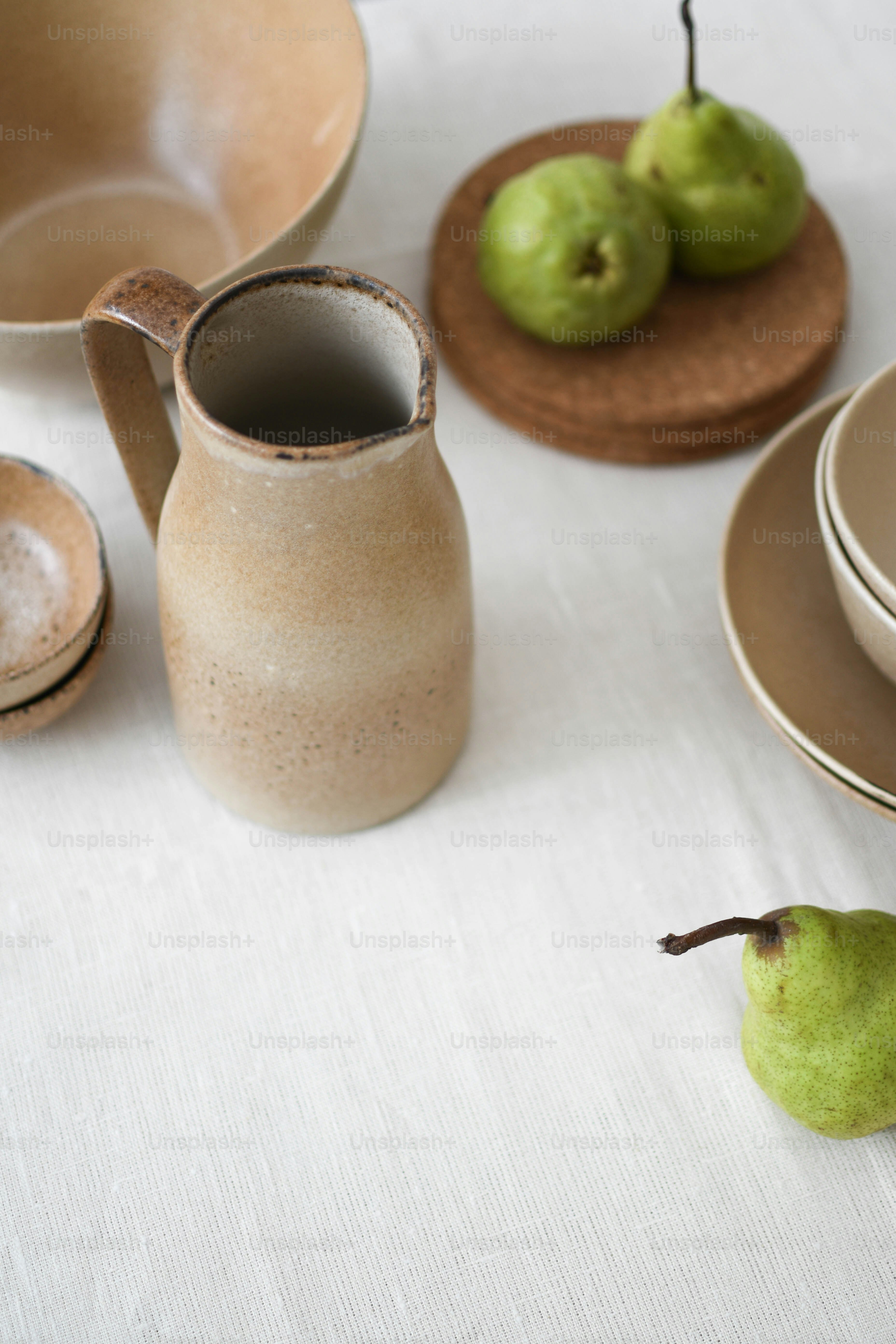 a table topped with plates and bowls filled with pears