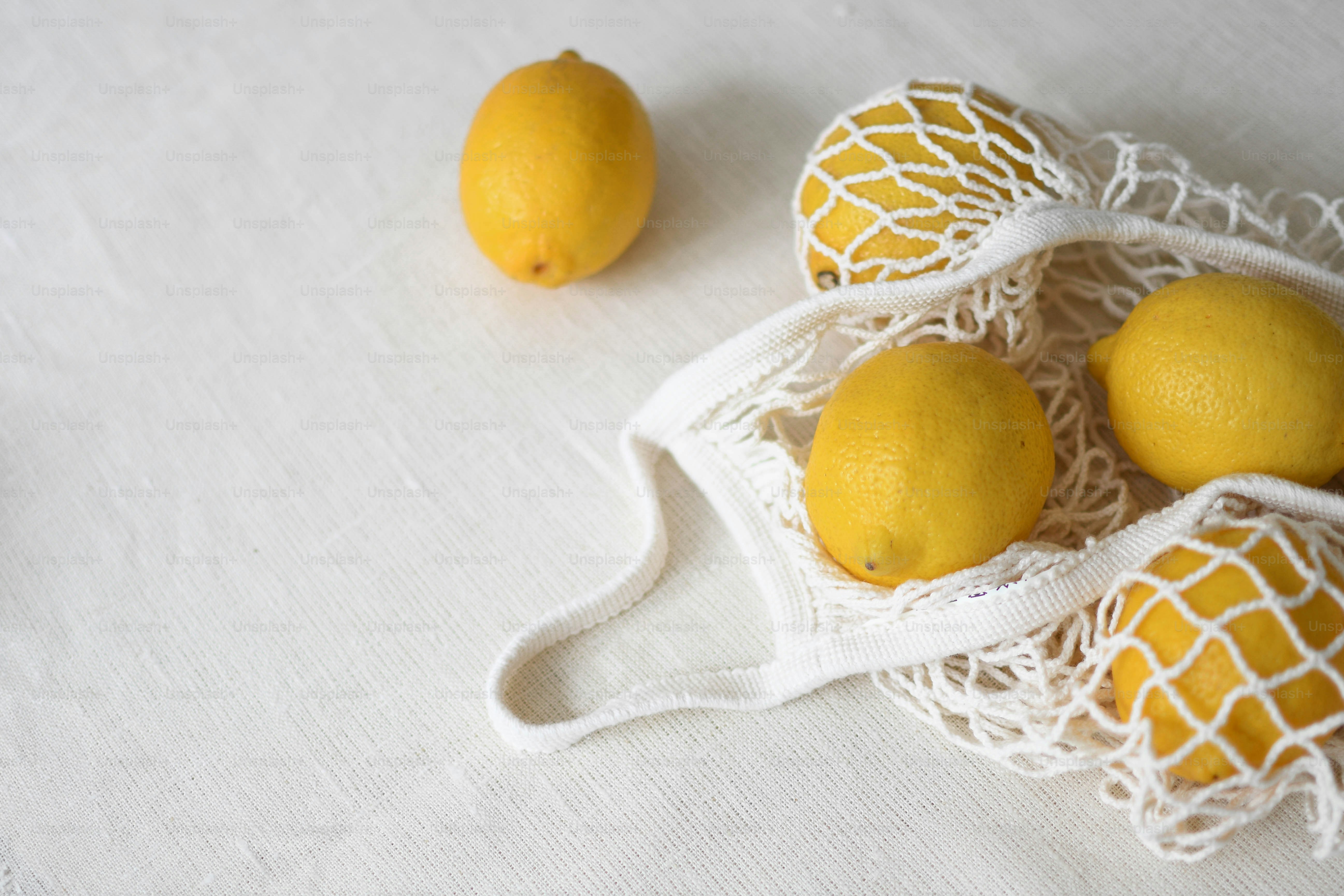 three lemons in a bag on a table