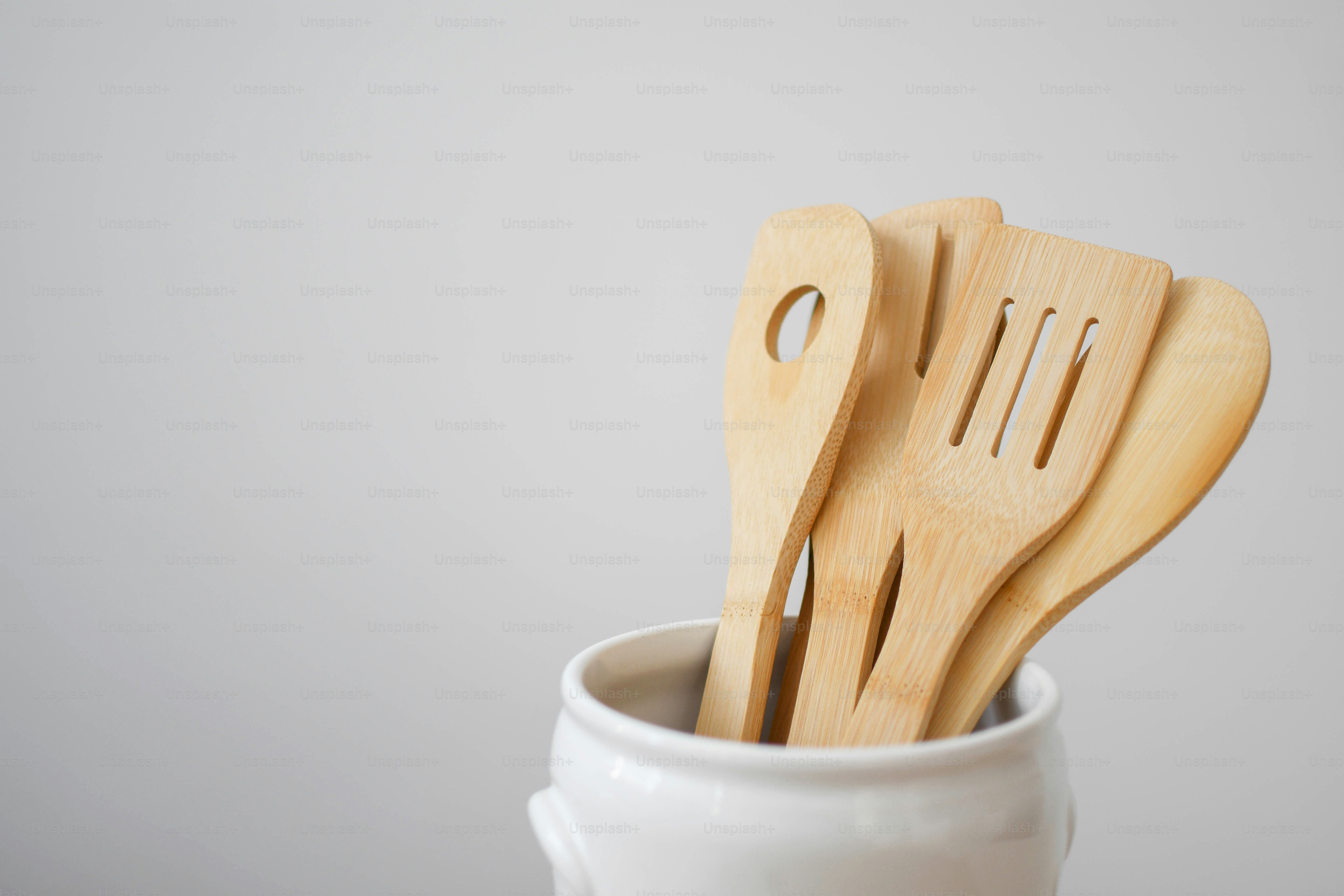 three wooden utensils in a white cup
