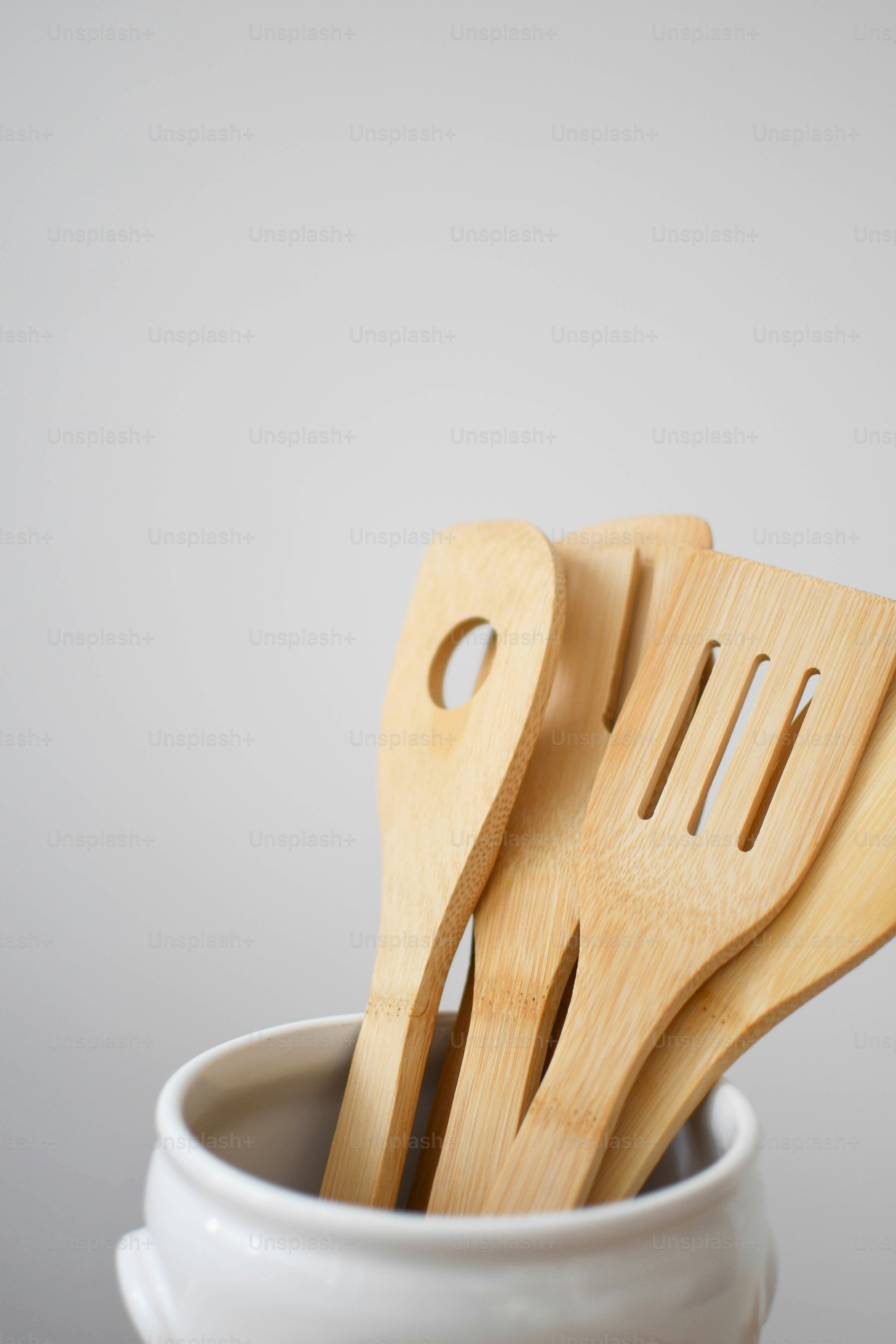 three wooden utensils in a white bowl